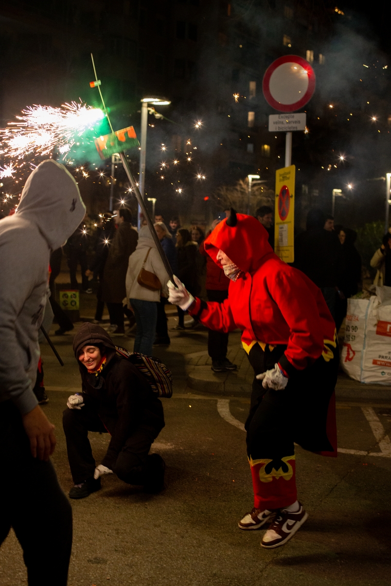 A runner bounces while spraying sparks at grinning audience members