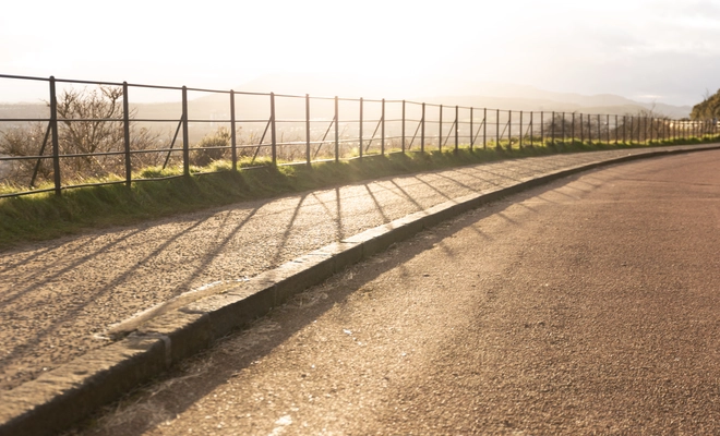 Sunlight streams through some railings, casting shadows towards the camera